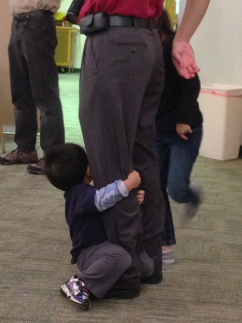 photo of child clinging to parent's leg