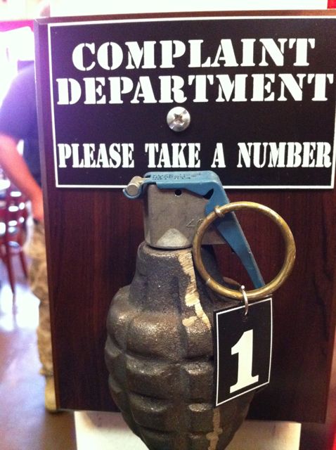 clever complaint department sign at California restaurant featuring a grenade