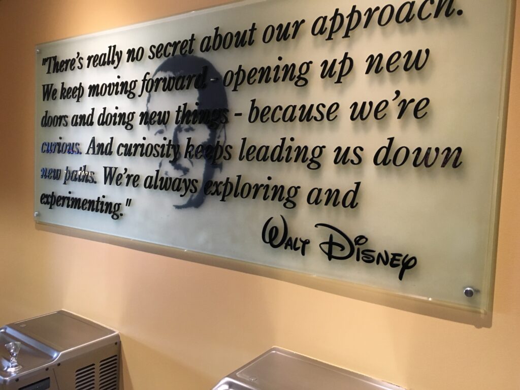 Walt Disney quote on wall above water fountain