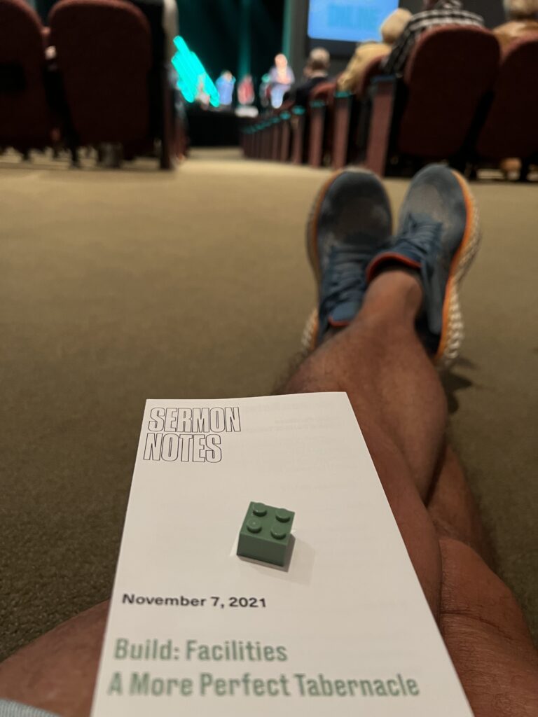 a man's leg sitting on church floor