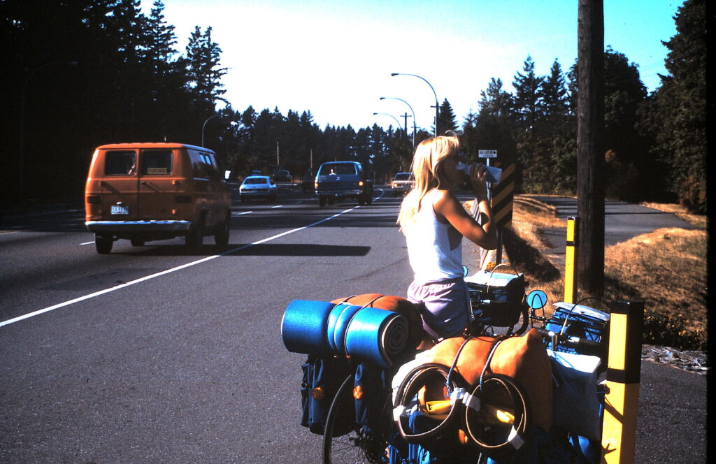 woman with two touring bicycles next to road