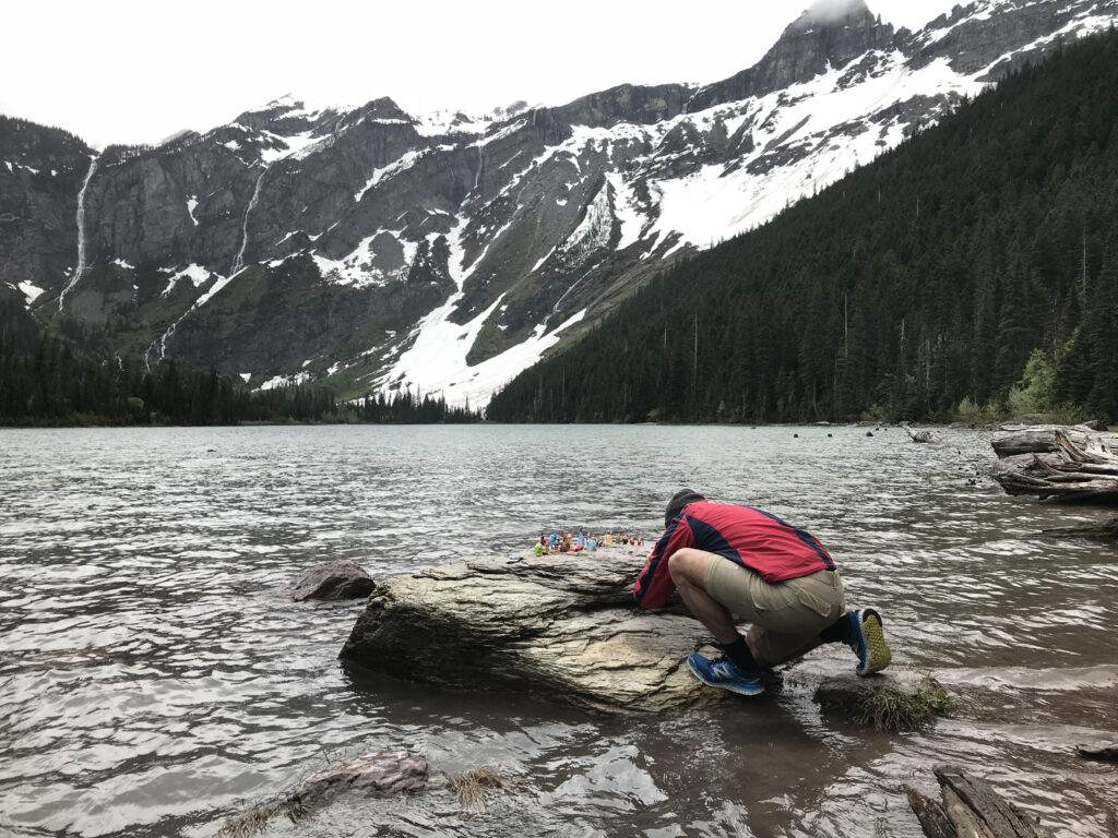 man taking close up photo at mountain lake