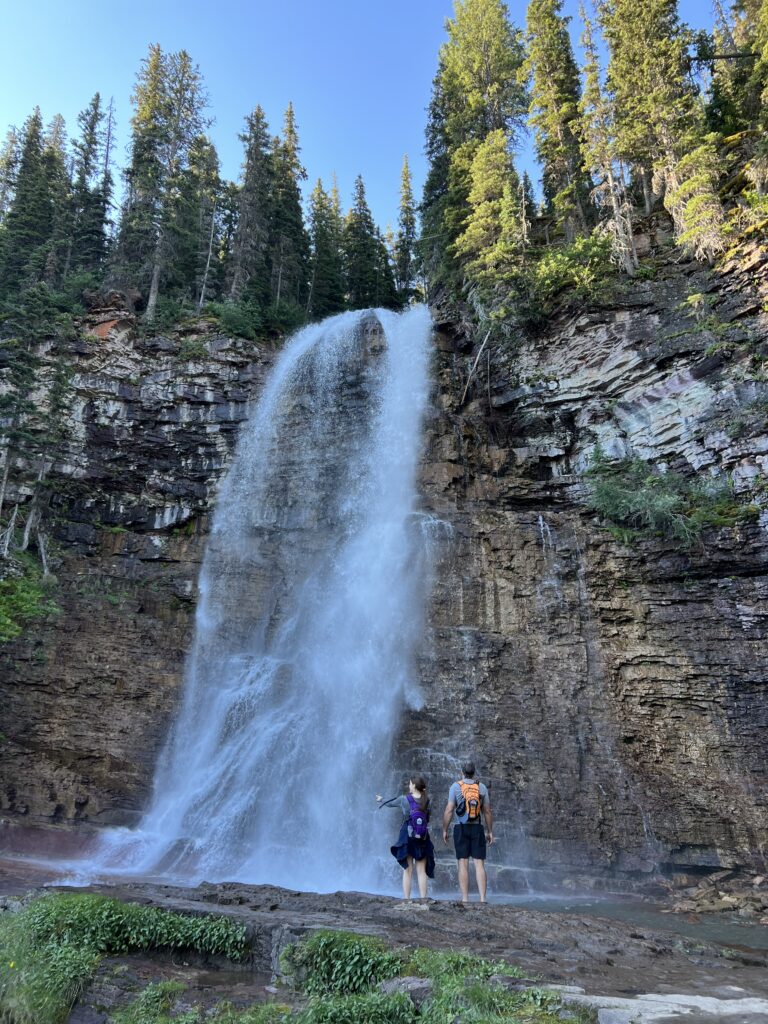 Two people next to a waterfall