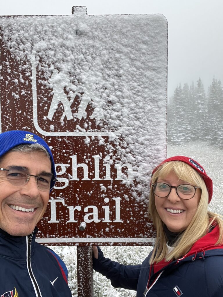 Couple at trail head sign in snow